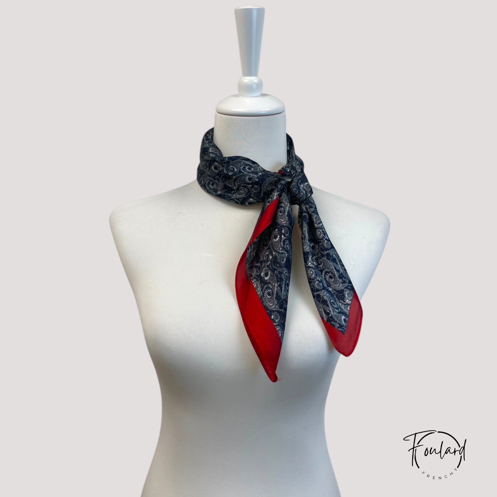 Détail des motifs argentés sur fond bleu marine du foulard