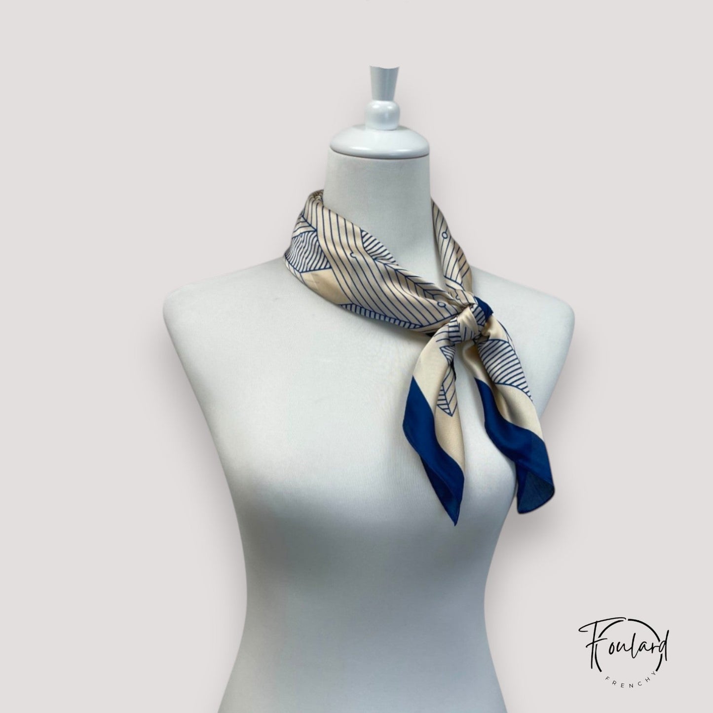 Foulard rose en polyester, posé sur une surface blanche