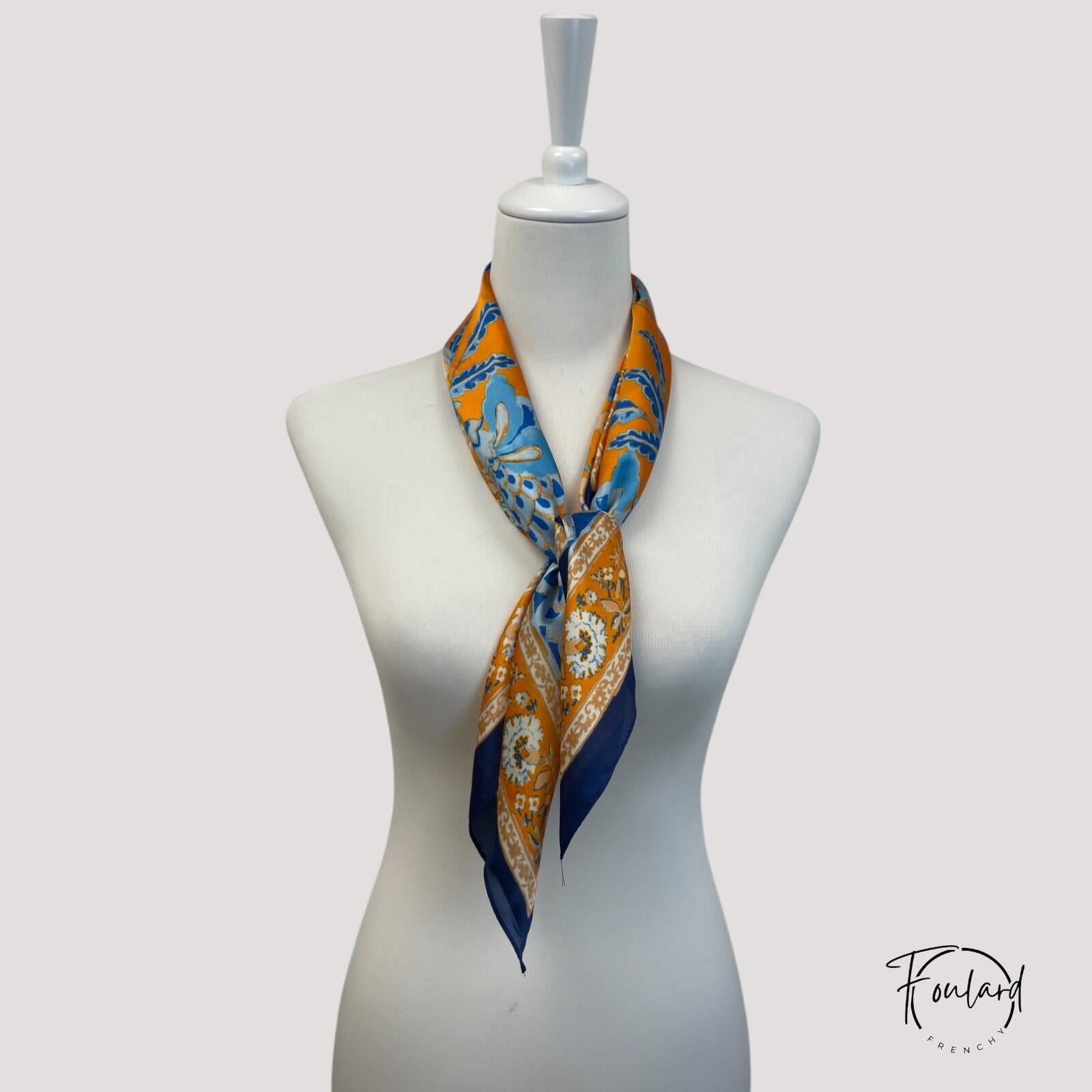 Détail du motif floral bleu et orange sur foulard