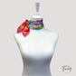 Détail du motif abstrait vibrant sur fond ivoire du foulard