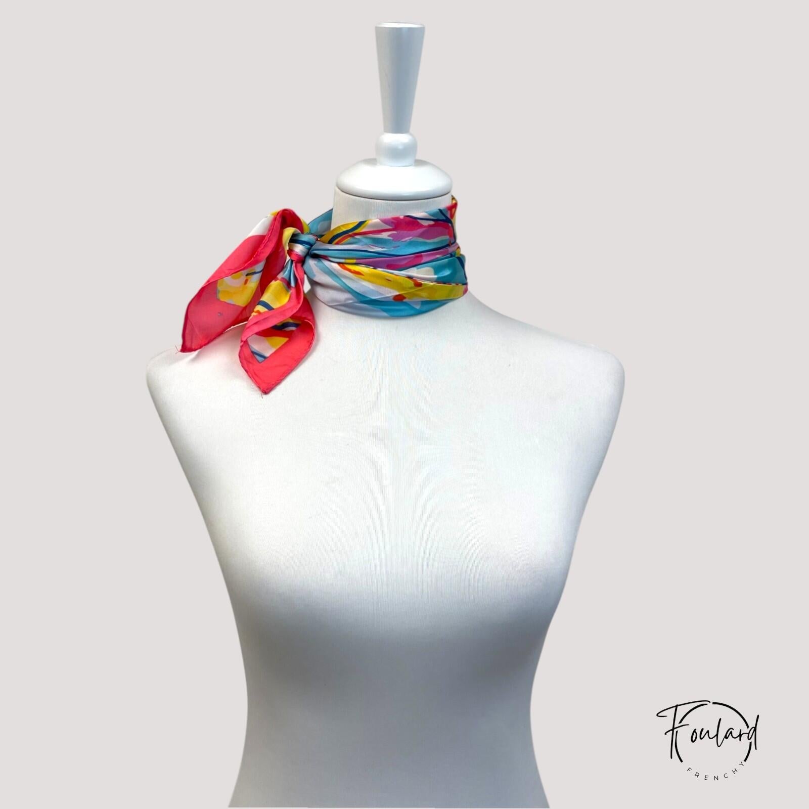 Détail du motif abstrait vibrant sur fond ivoire du foulard
