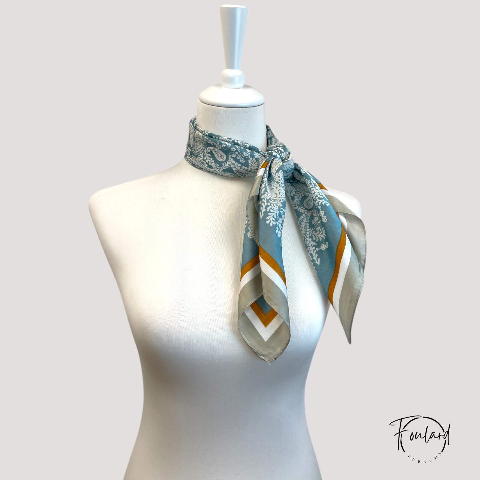 Foulard vert pastel drapé, mettant en valeur sa texture