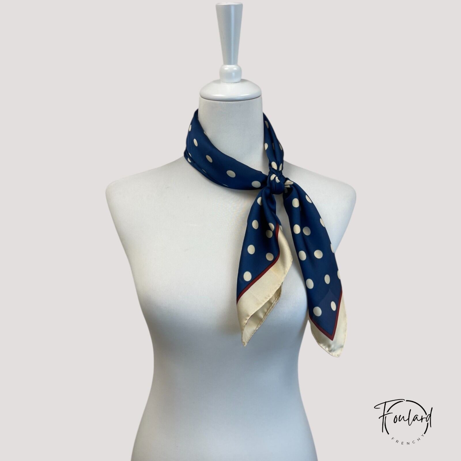 Détail de la bordure contrastée rouge et beige du foulard