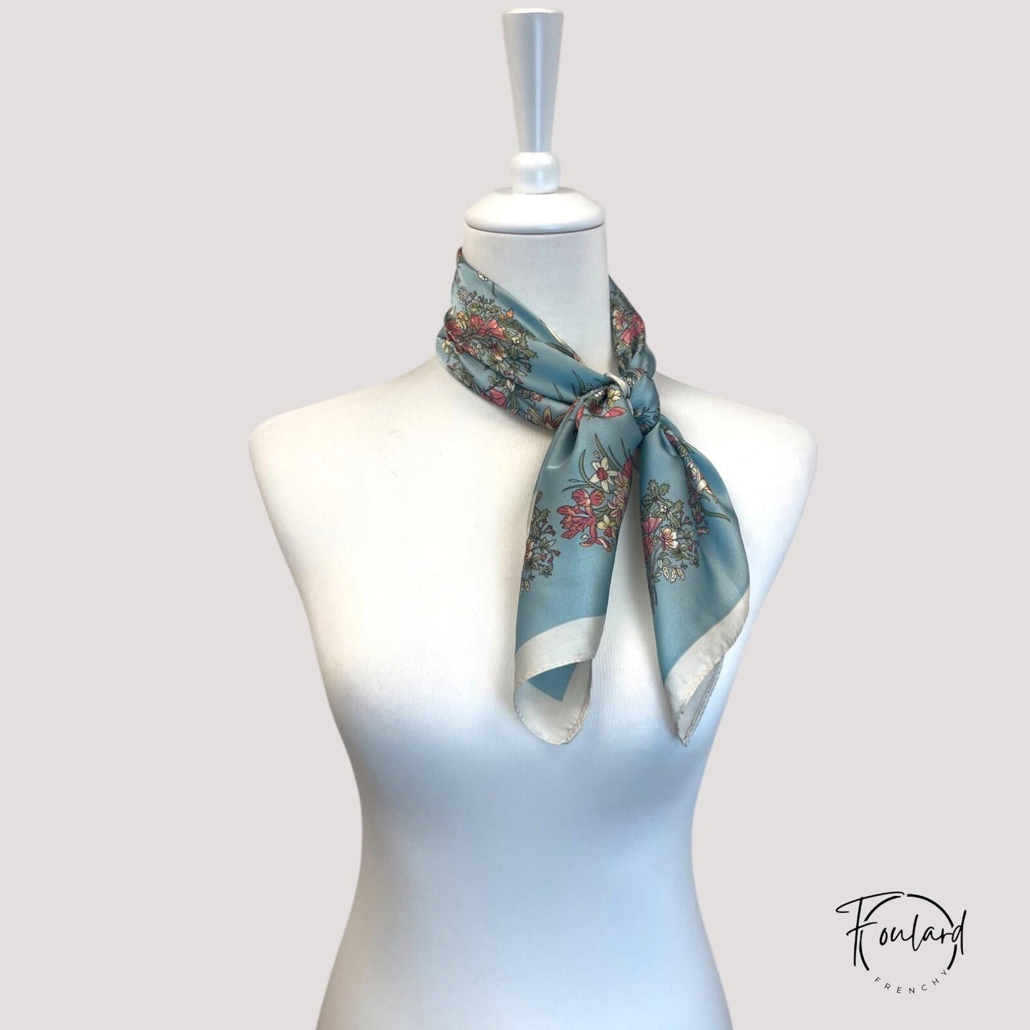 Bordure ivoire encadrant le motif floral sur fond bleu