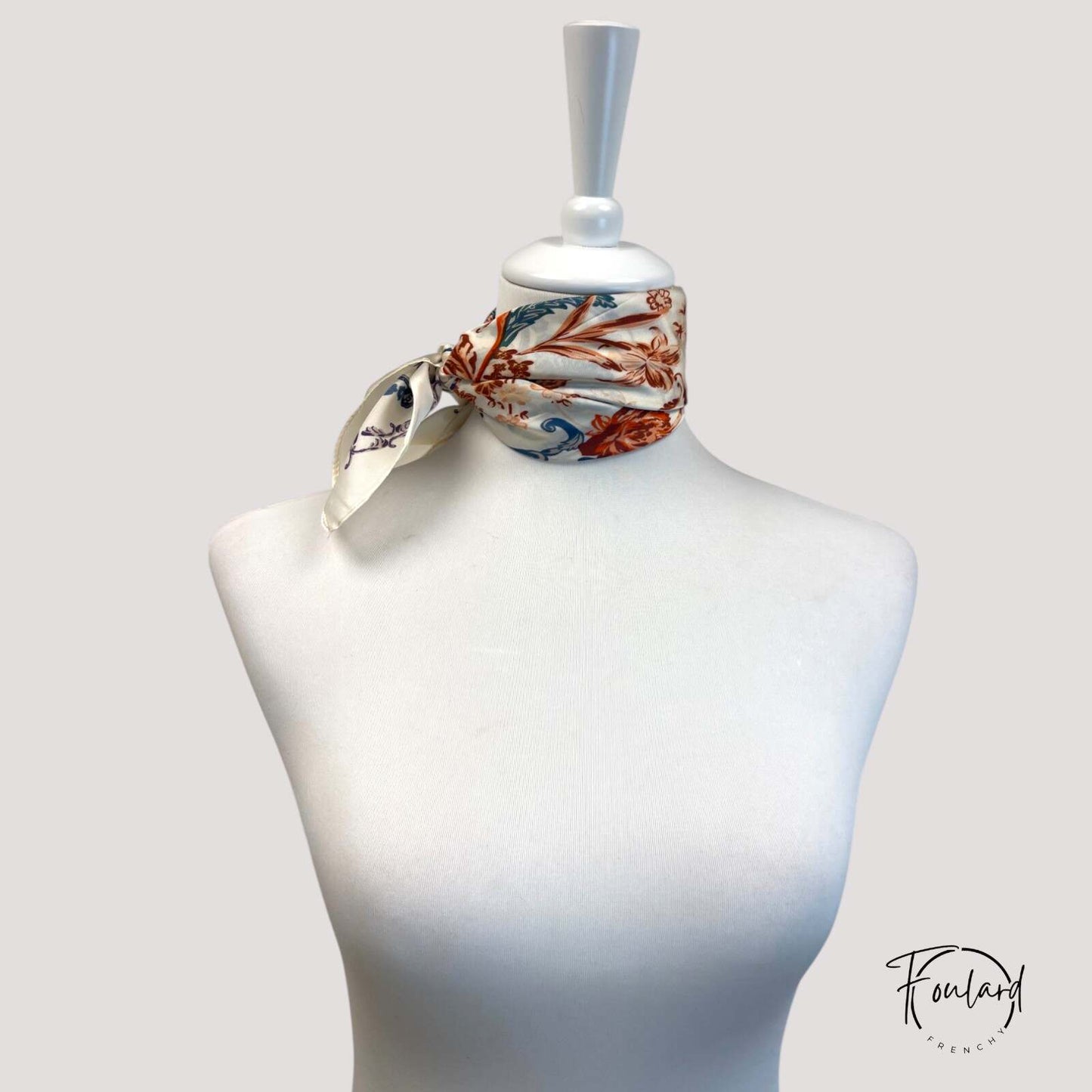 Zoom sur les volutes et fleurs stylisées du foulard