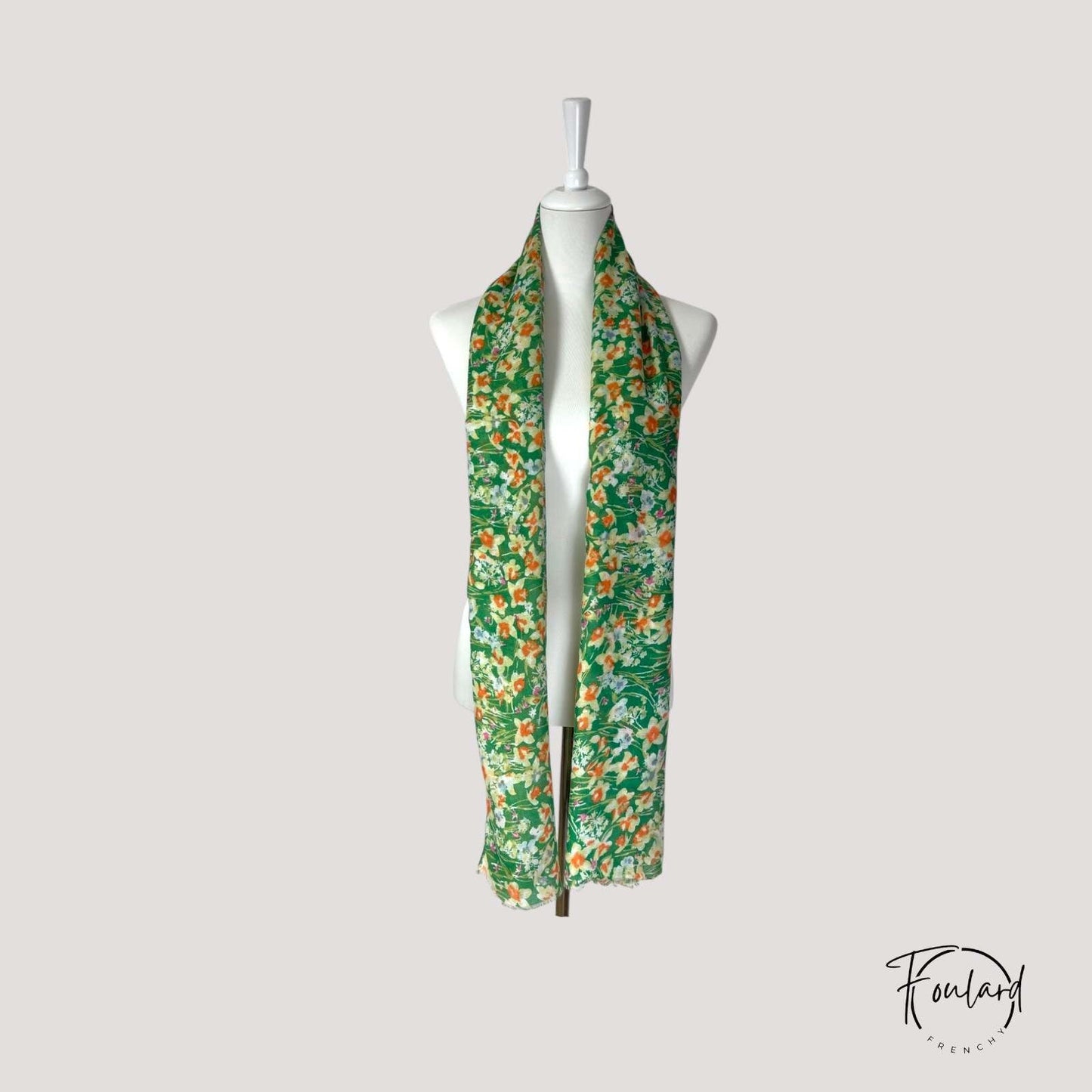Gros plan sur le motif floral du foulard vert en polyester