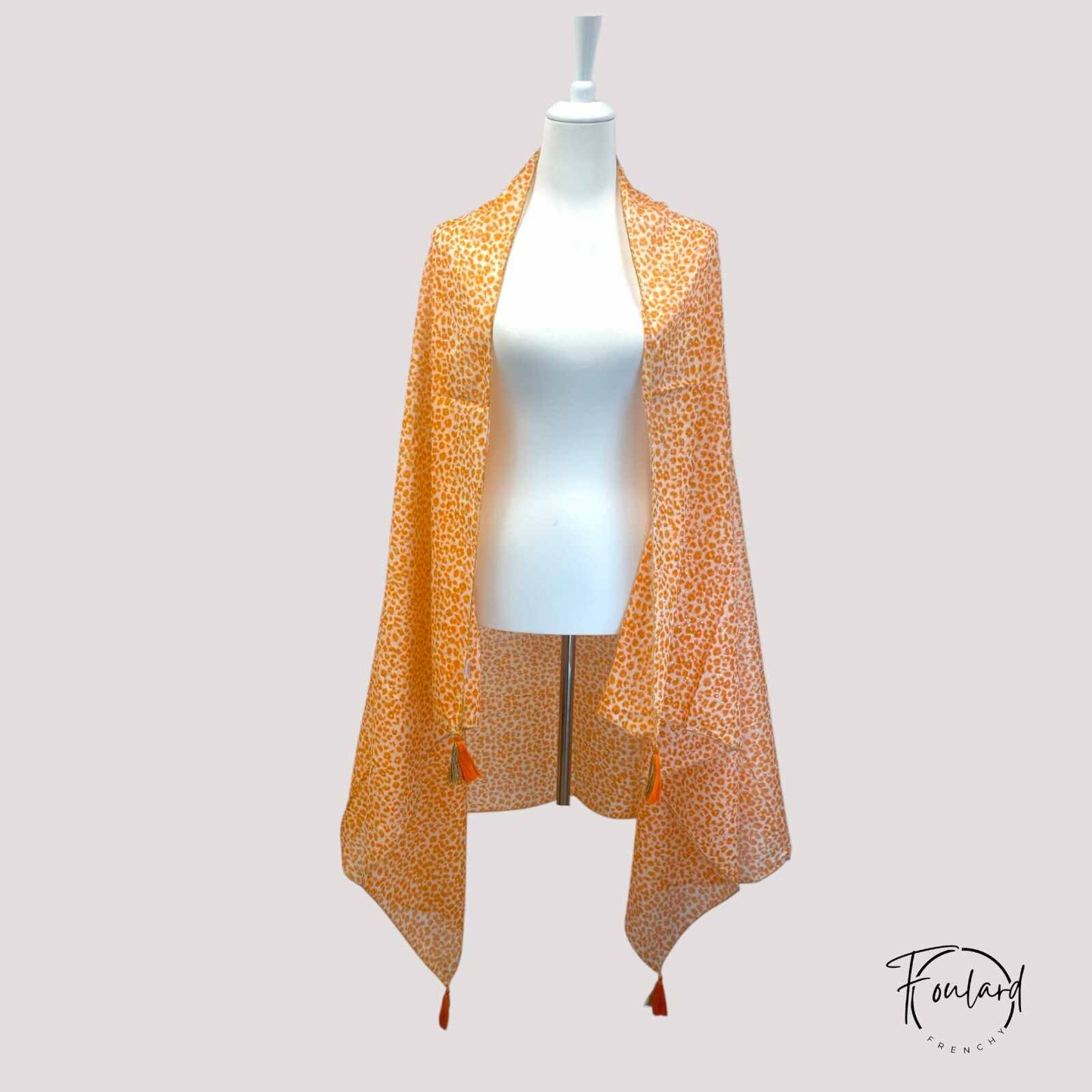 Foulard orange léopard avec pompons dorés en gros plan