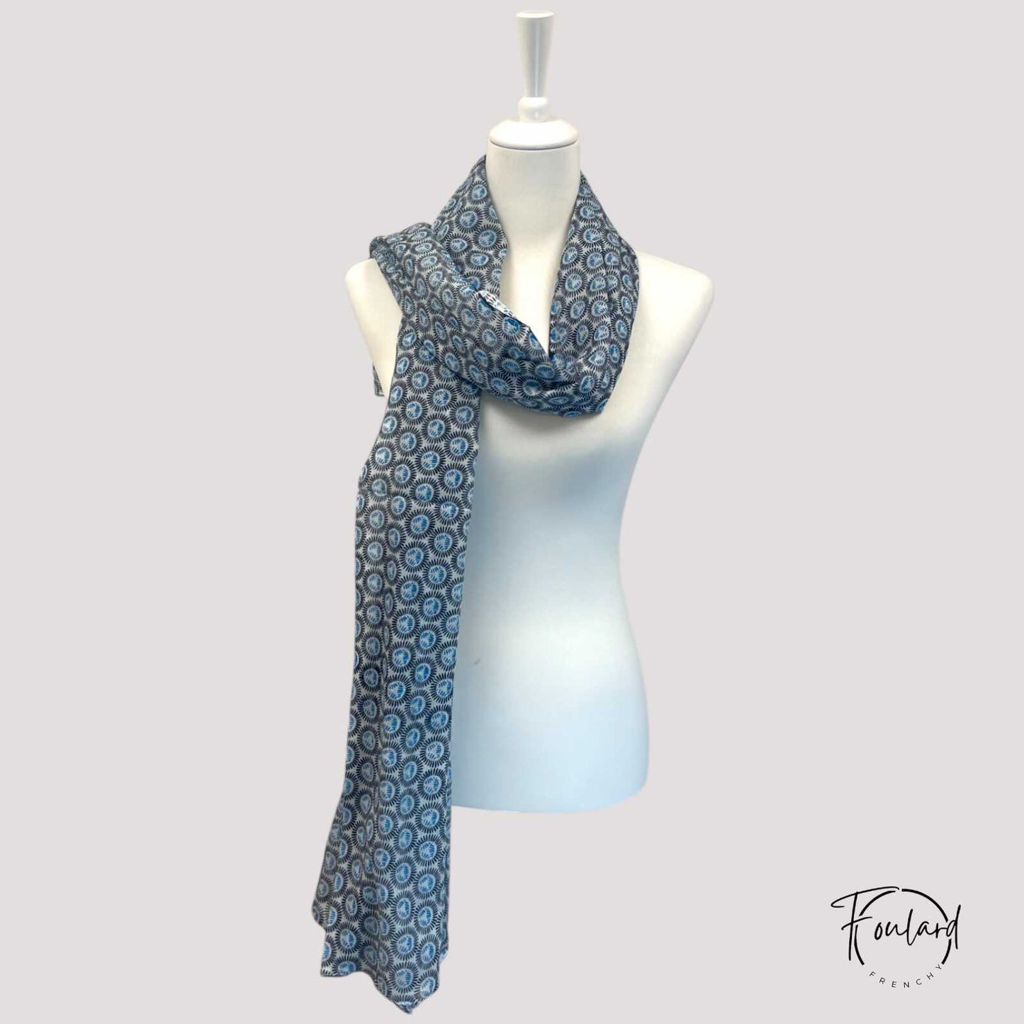 Gros plan sur le motif circulaire bleu et noir du foulard