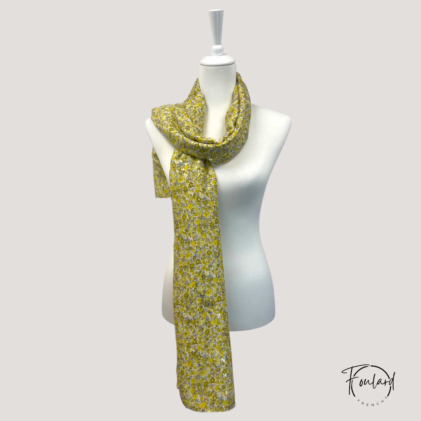Détail du motif floral jaune et gris du foulard