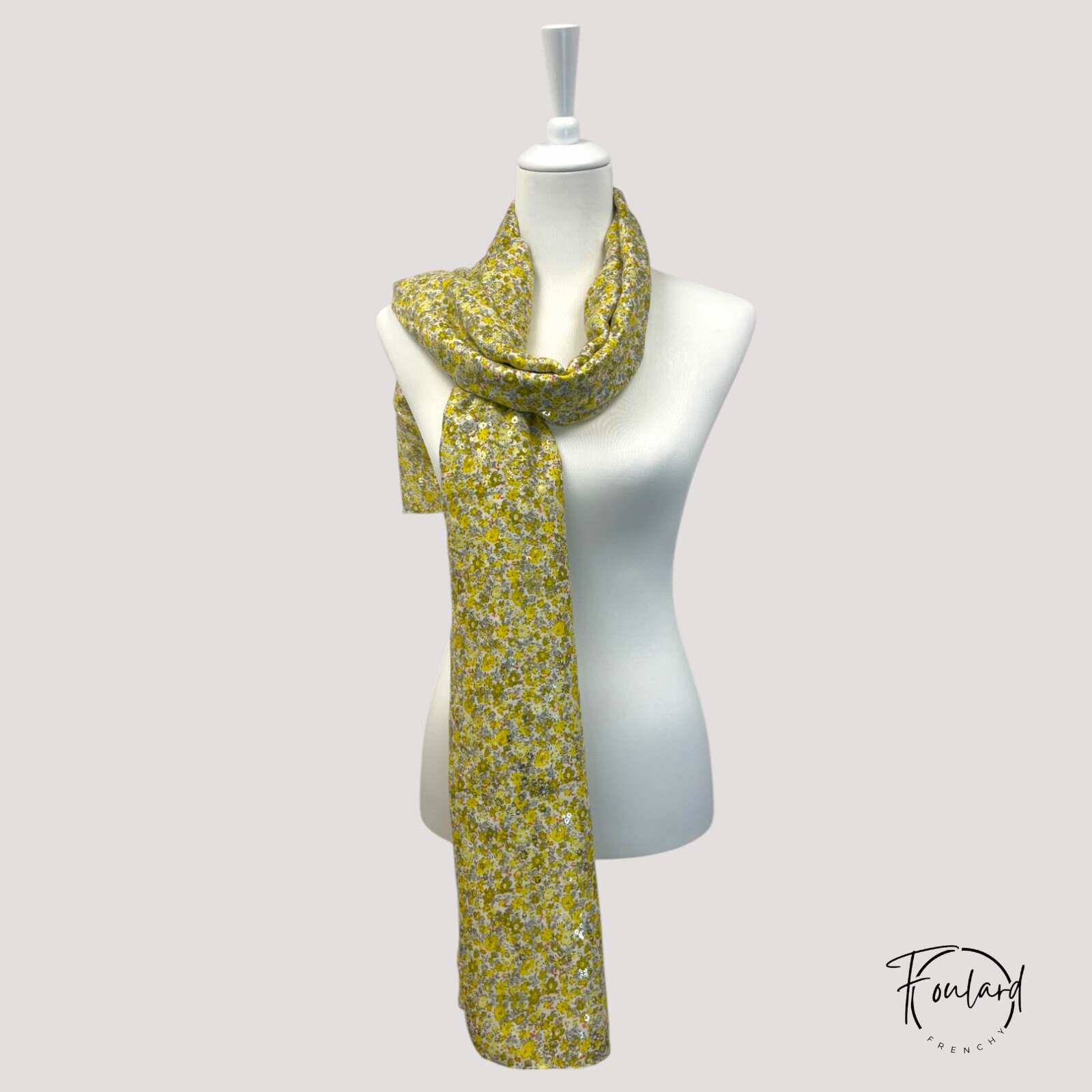 Détail du motif floral jaune et gris du foulard