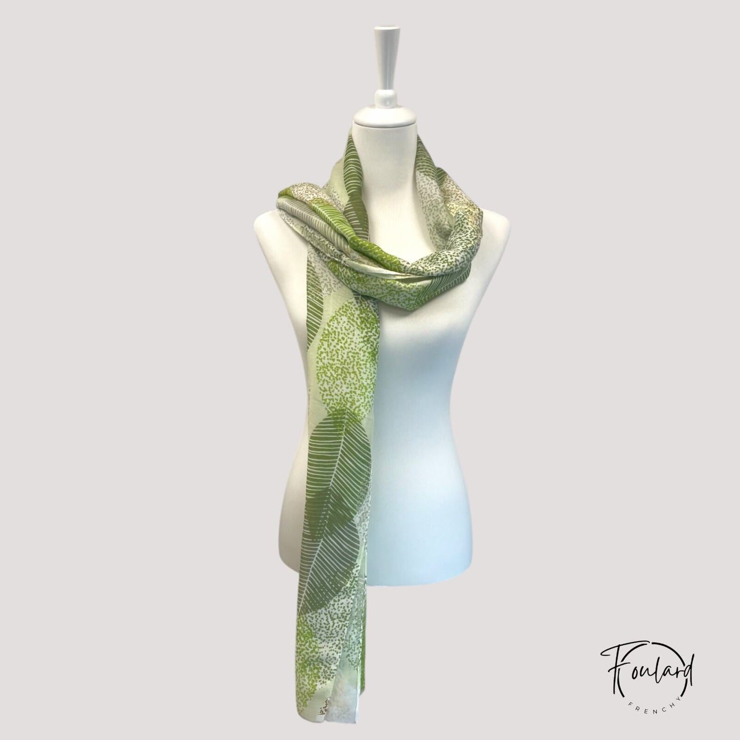 Détail du motif feuillage vert et doré sur foulard