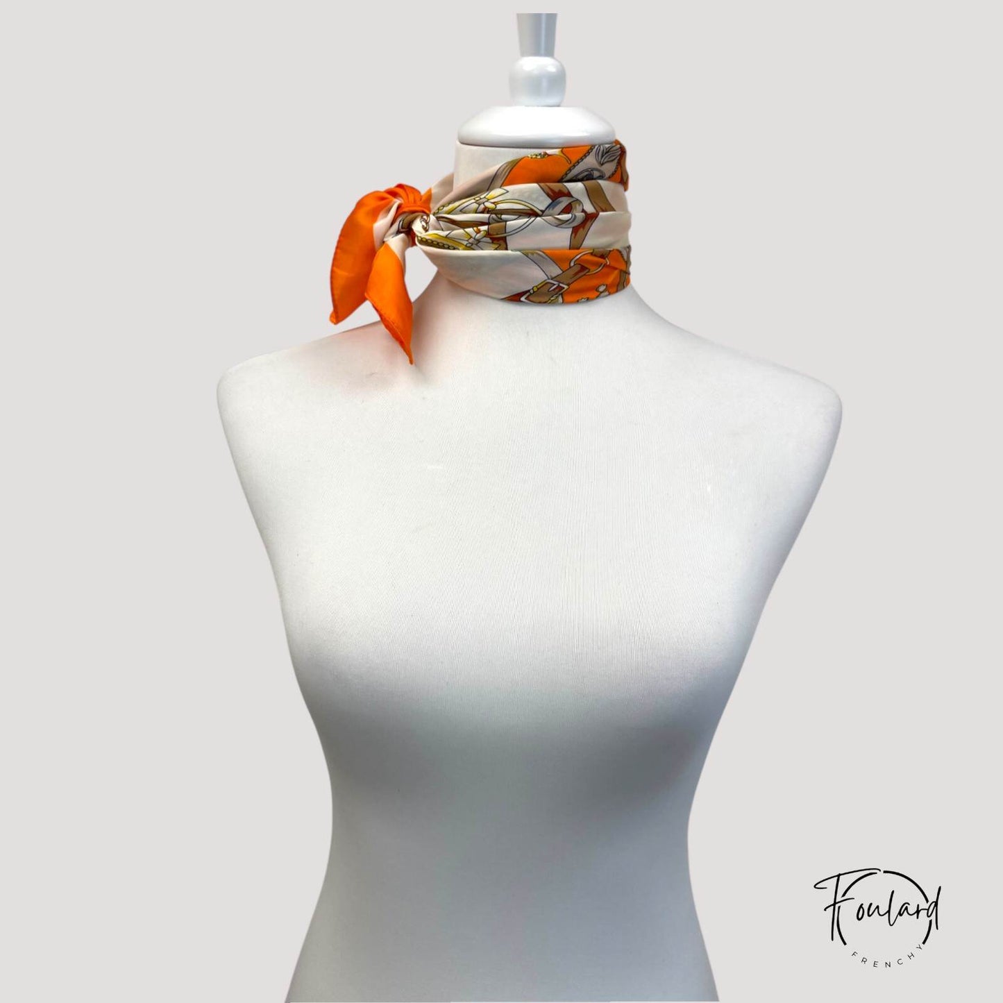 Vue rapprochée du foulard orange, texture polyester en détail