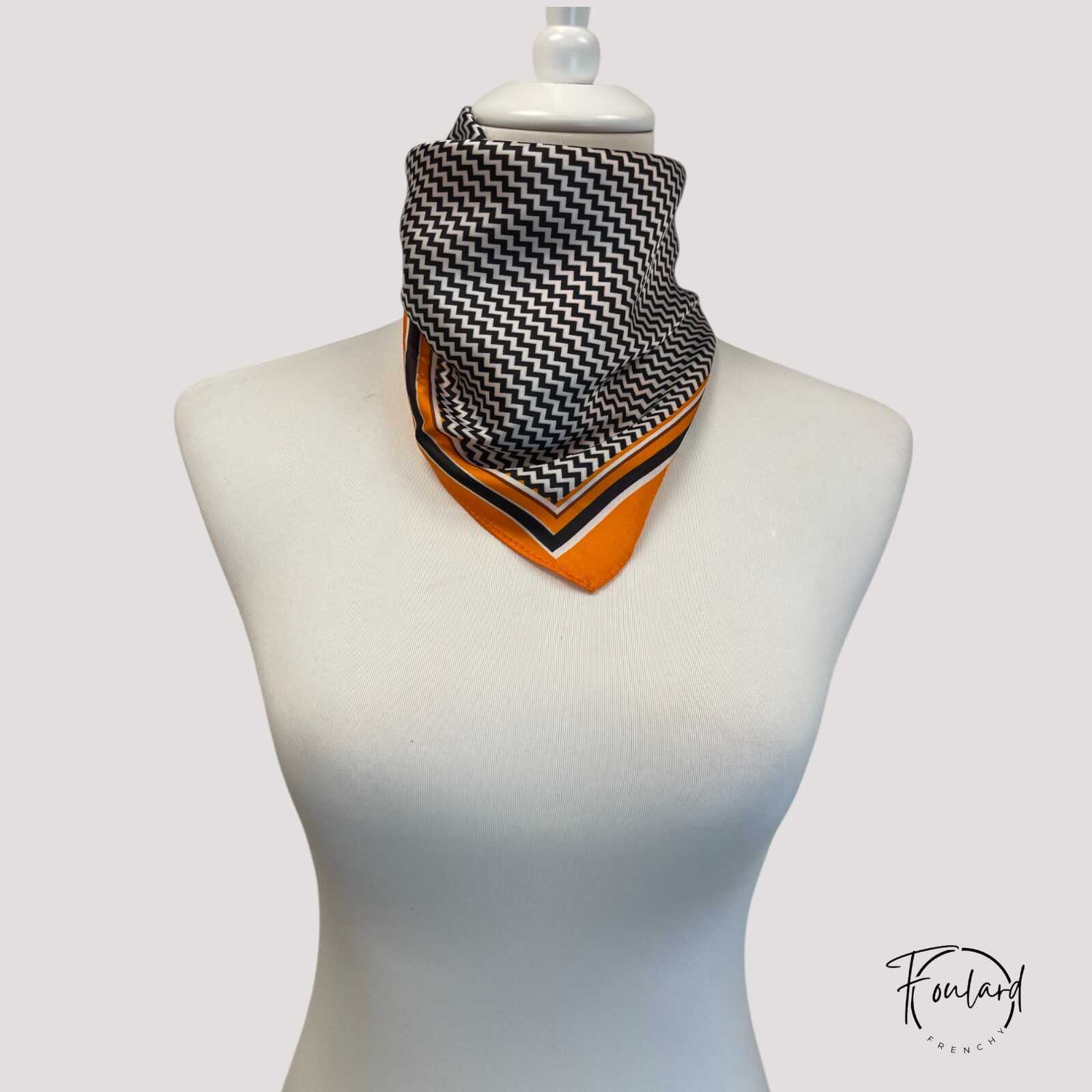 Foulard carré motif bohème posé sur une surface blanche