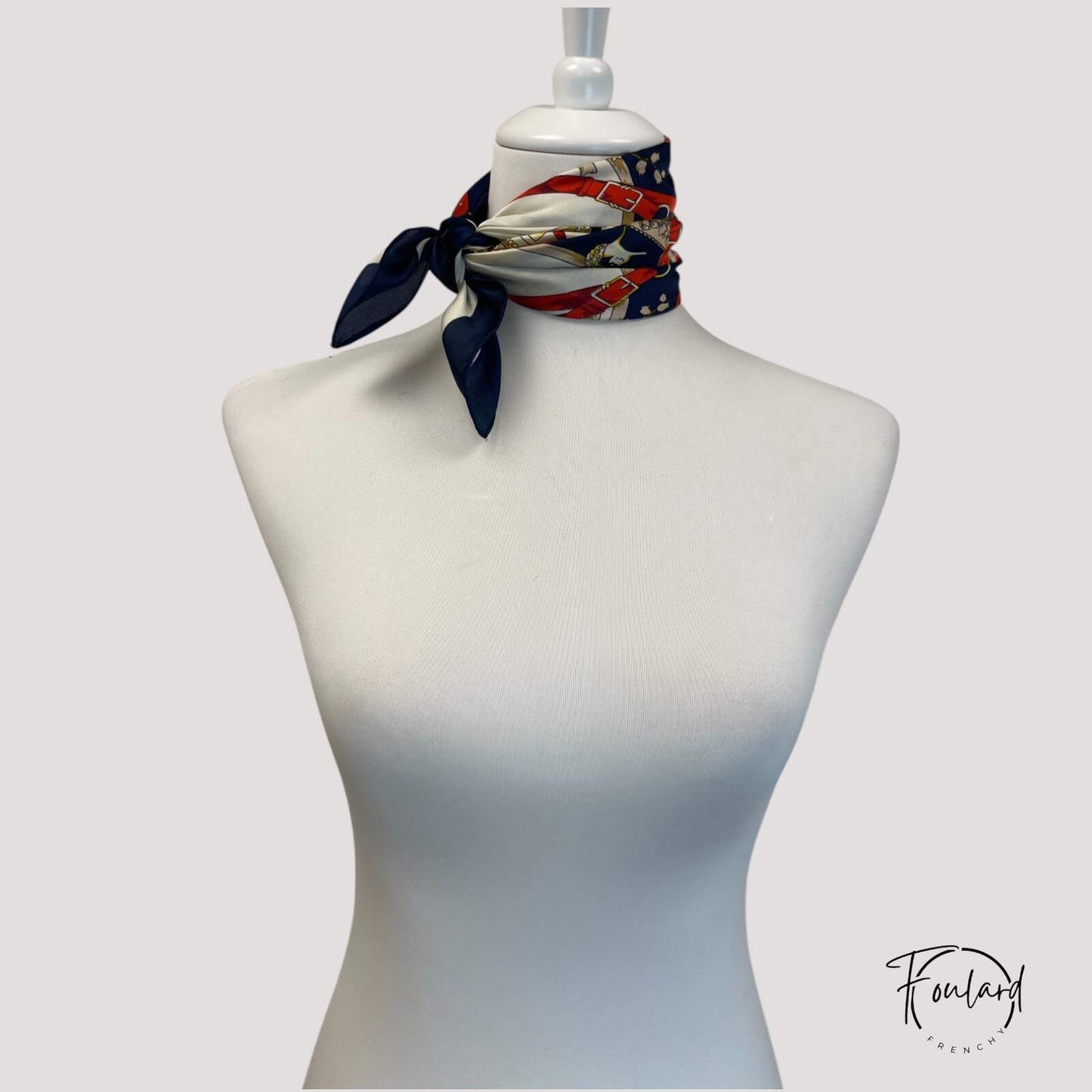 Foulard carré bleu plié en triangle sur une table