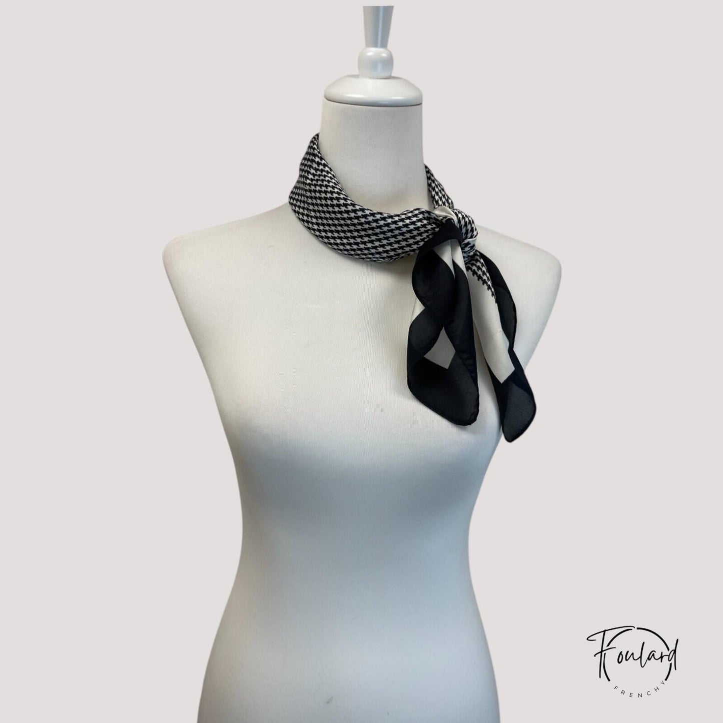 Foulard noir enroulé, montrant sa texture douce