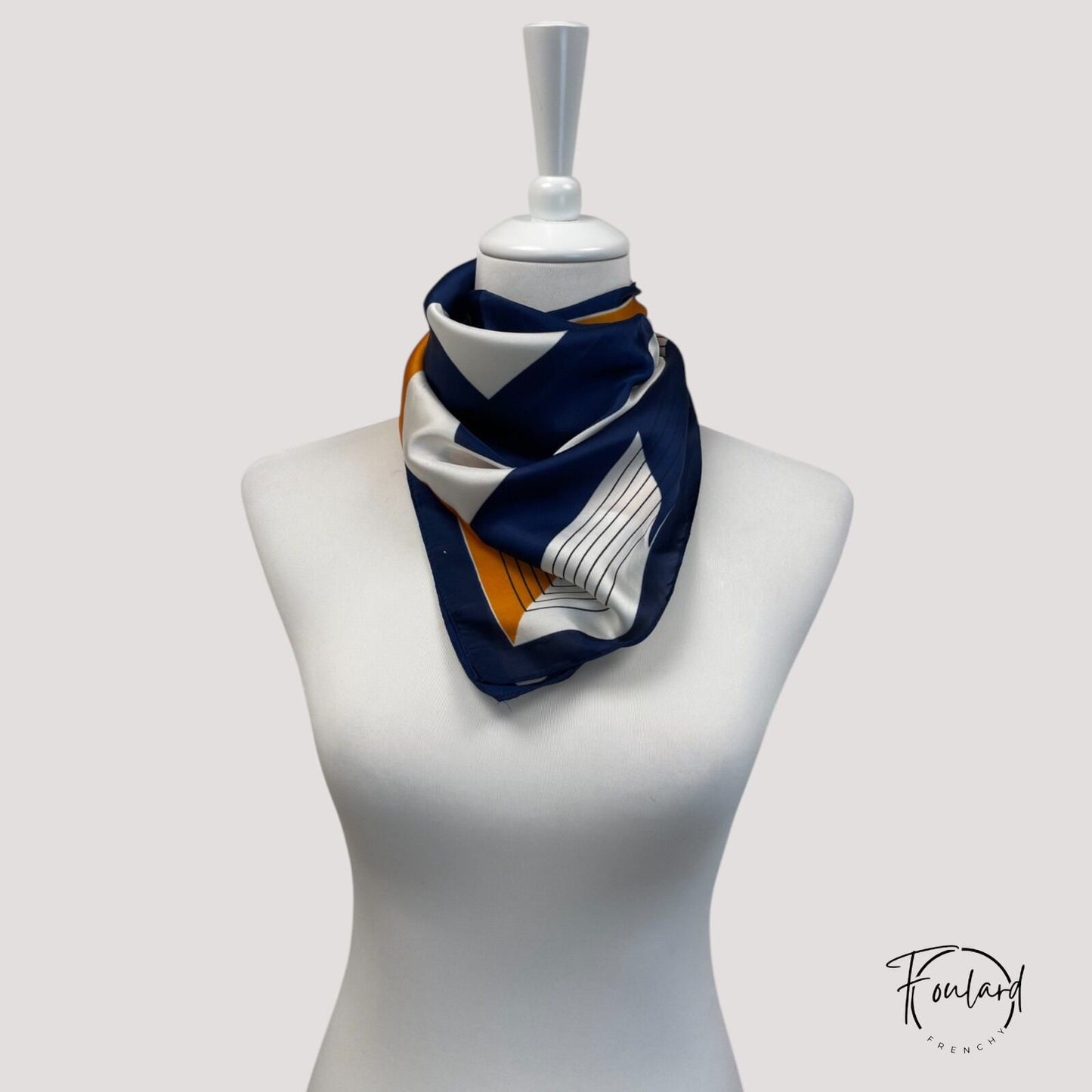 Détail du motif géométrique bleu, blanc et ocre du foulard