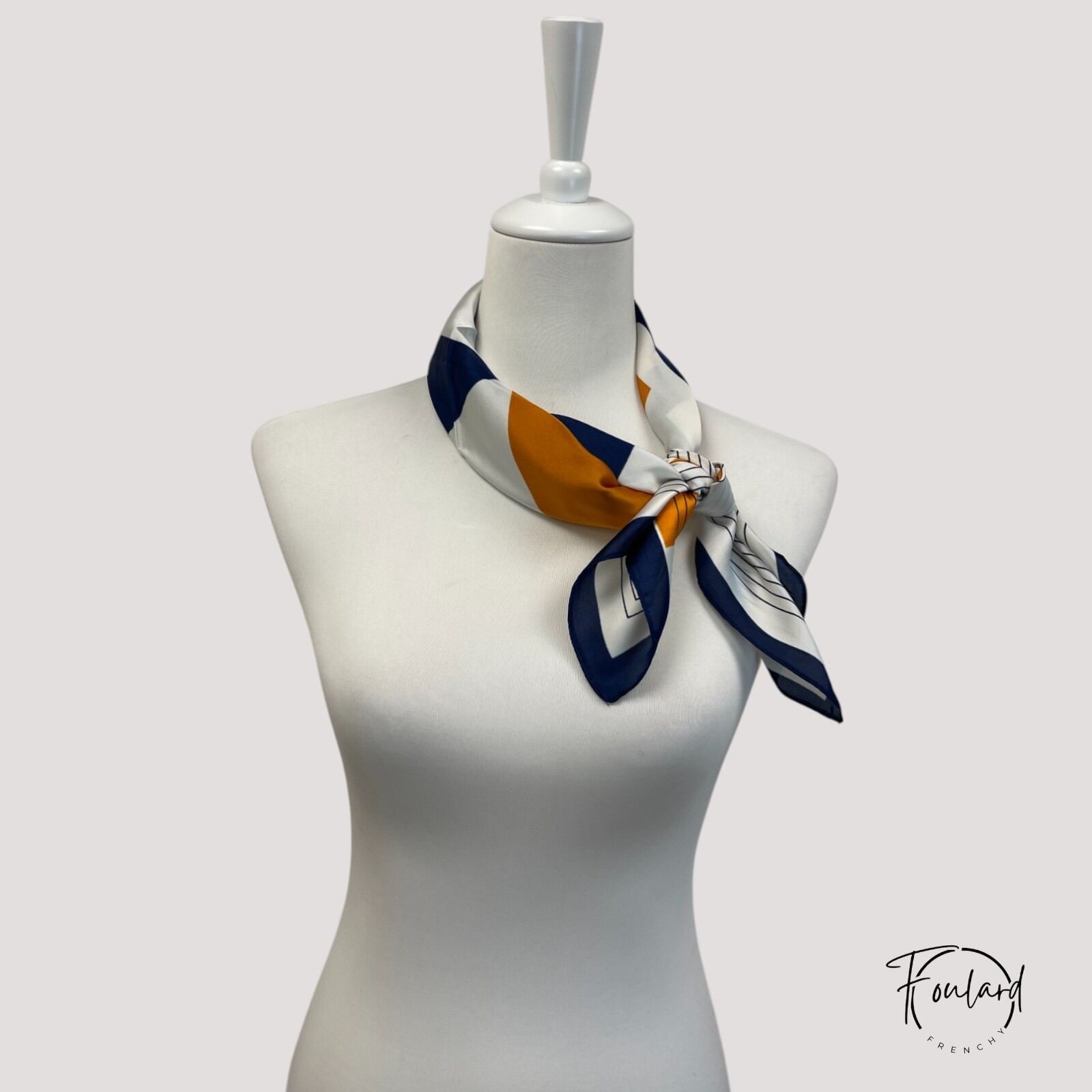 Foulard carré porté en bandeau, mettant en valeur le motif graphique