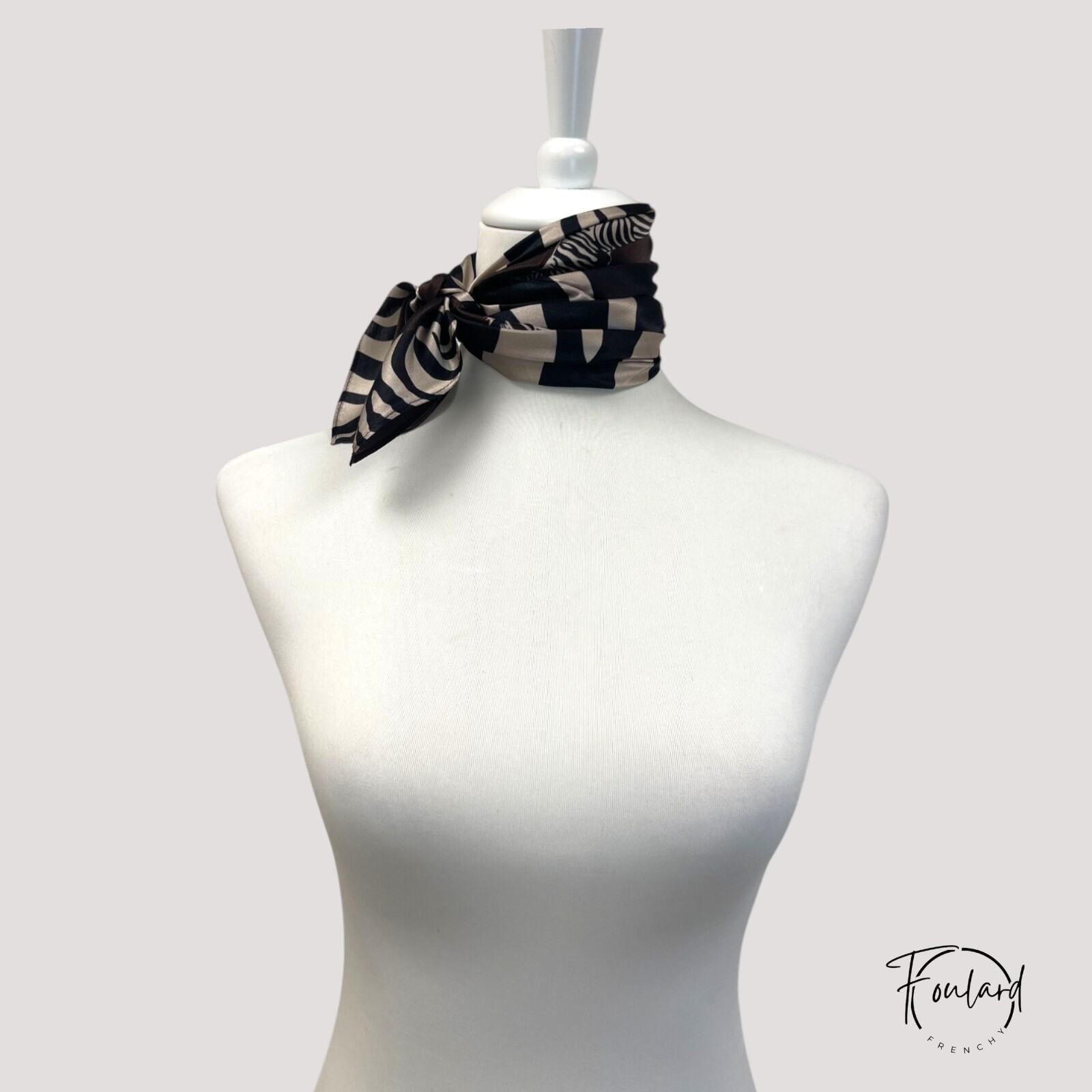 Détail du tissu soyeux marron avec motifs argentés