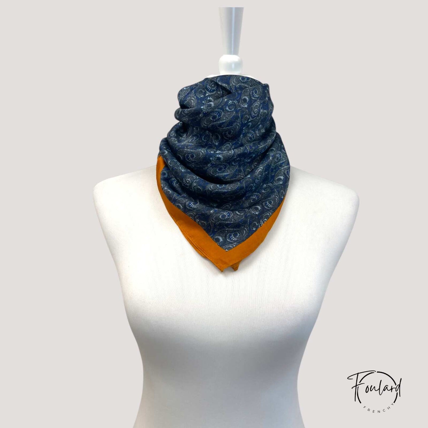 Foulard carré 70 cm posé sur une surface en bois clair