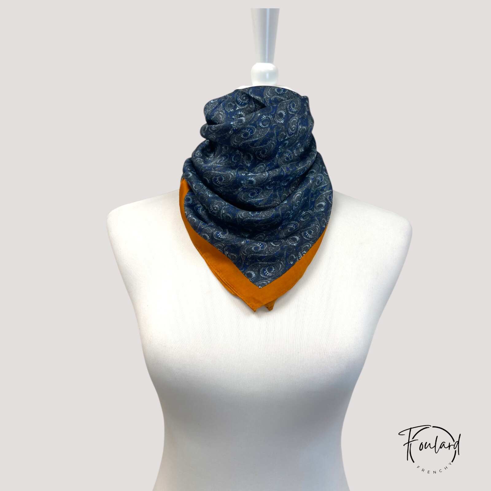 Foulard carré 70 cm posé sur une surface en bois clair