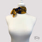 Zoom sur les coins du foulard bleu, mettant en valeur les finitions