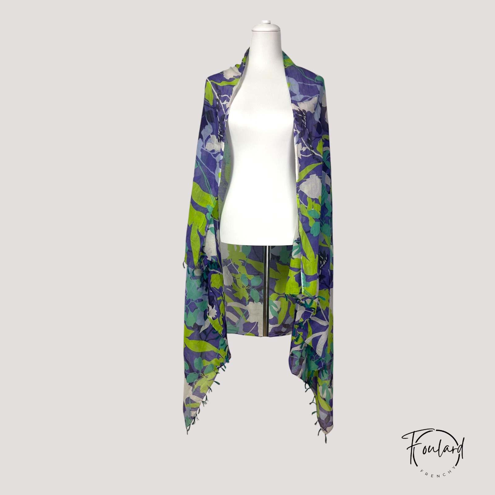 Détail des pompons verts sur foulard à motifs feuillage