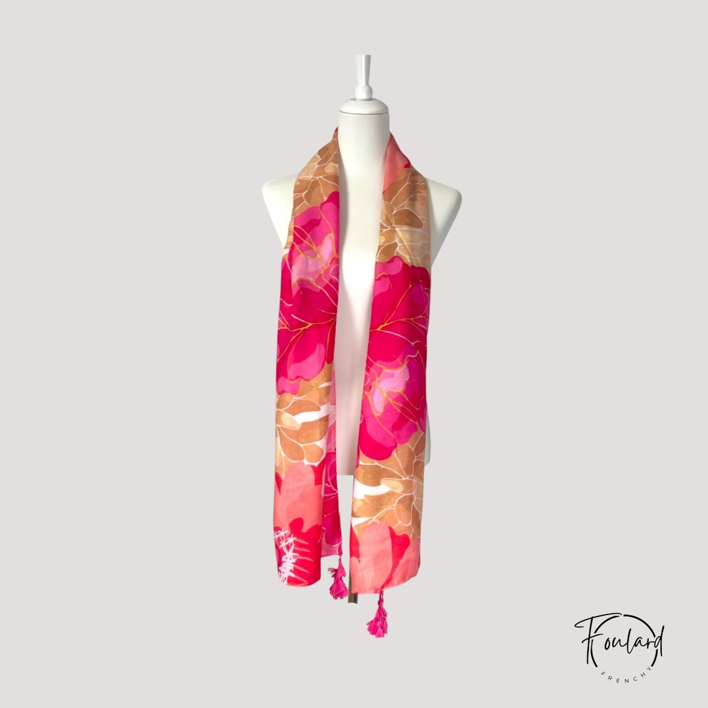 Gros plan sur le motif floral du foulard rose et corail