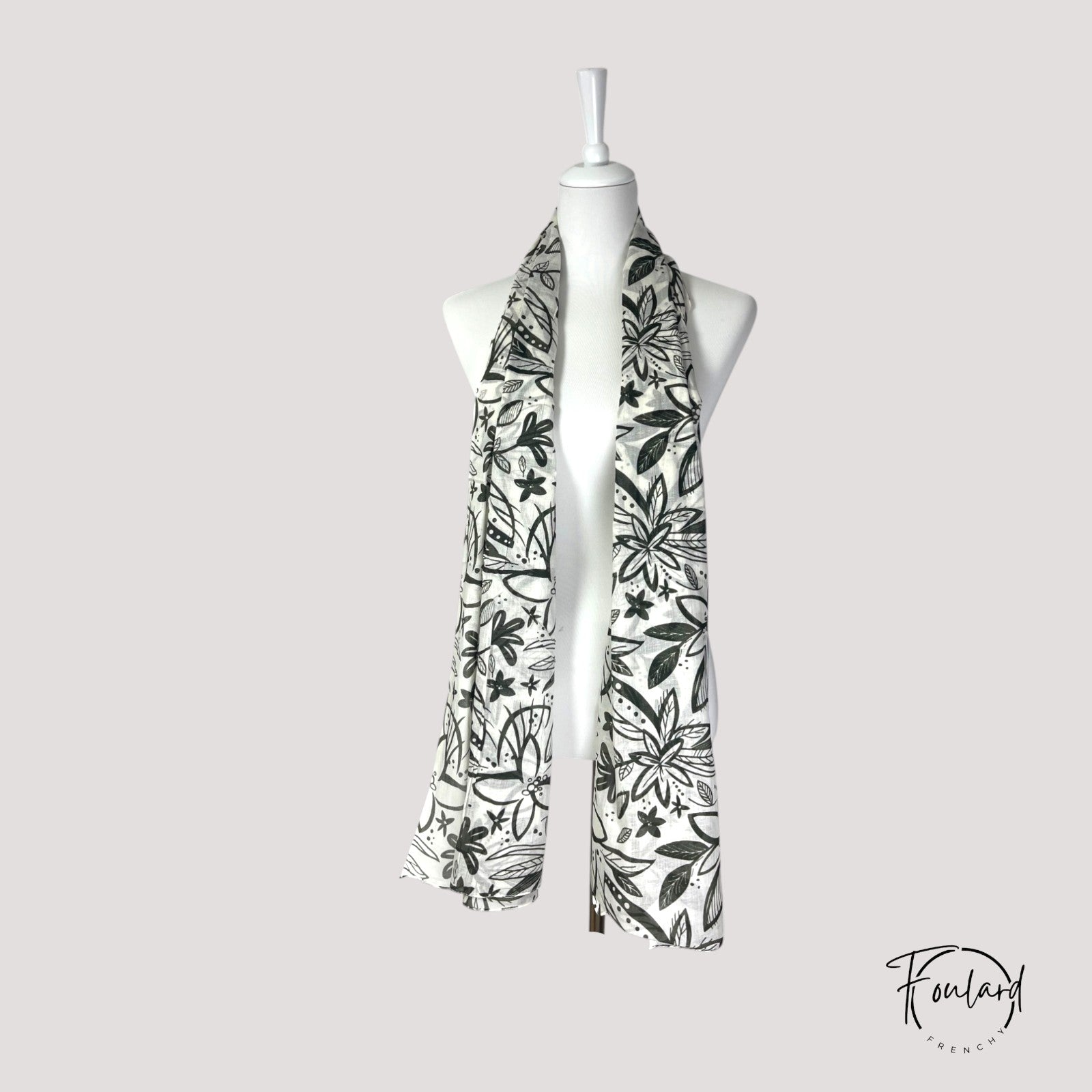 Gros plan sur le motif floral kaki du foulard en coton