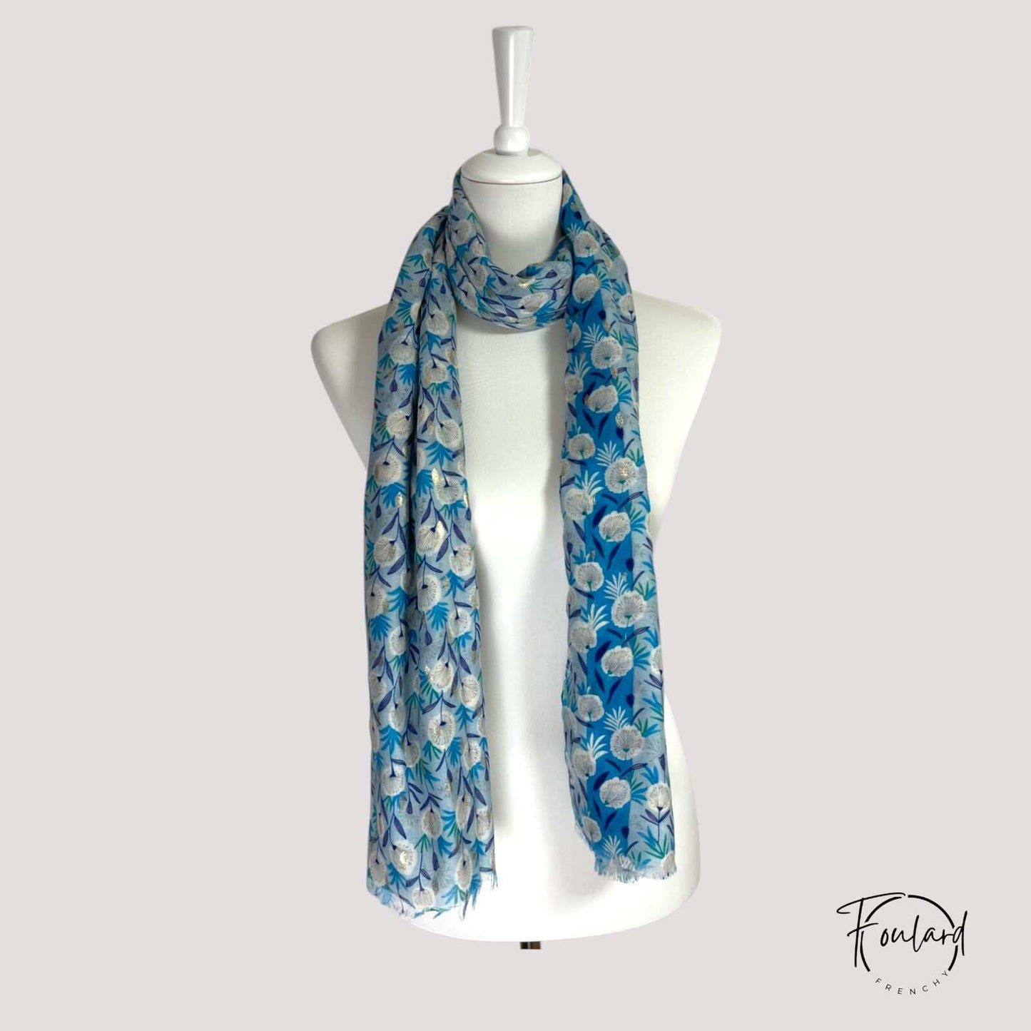Détail du motif floral bleu et doré sur foulard