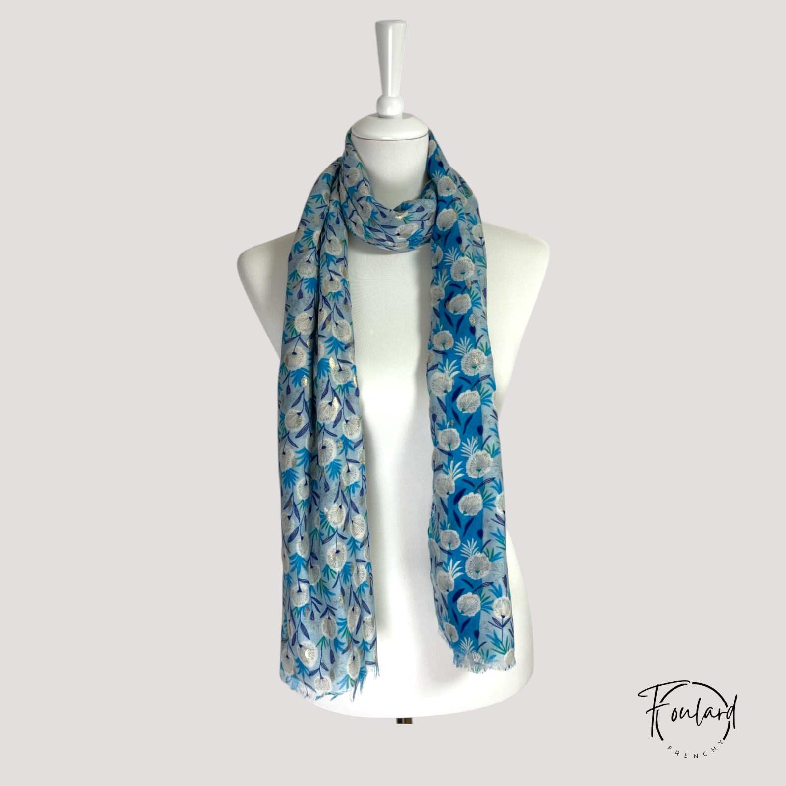 Détail du motif floral bleu et doré sur foulard