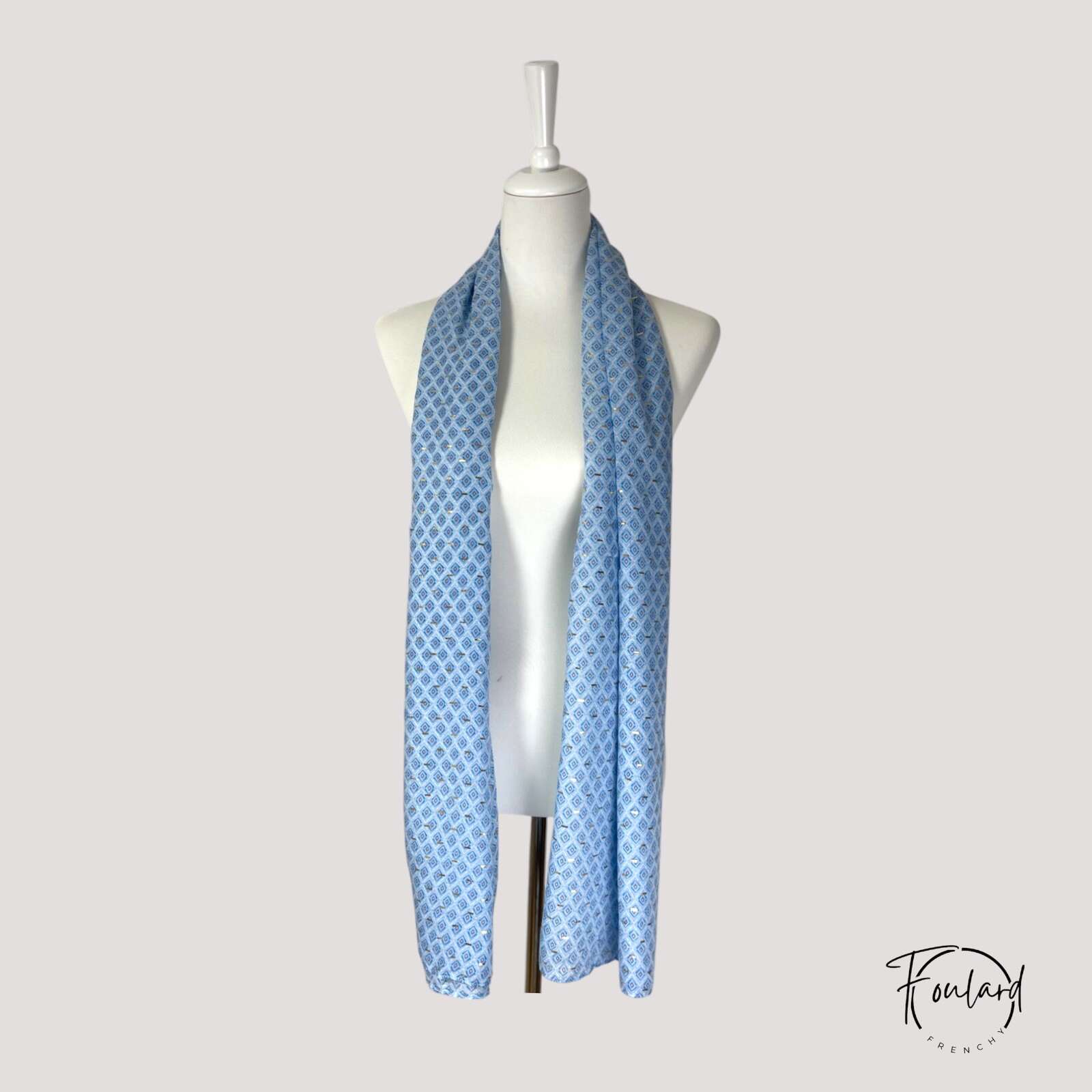 Détail des motifs losange dorés sur fond bleu pastel