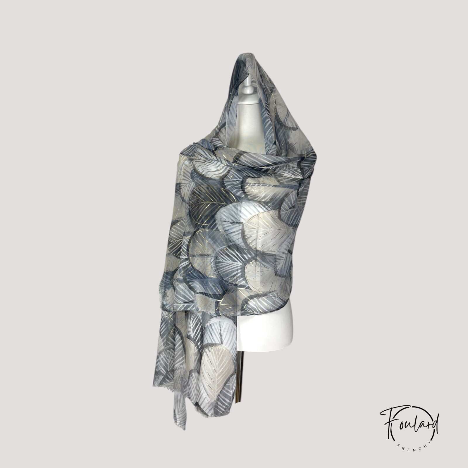 Foulard noir porté en étole, motifs dorés subtils