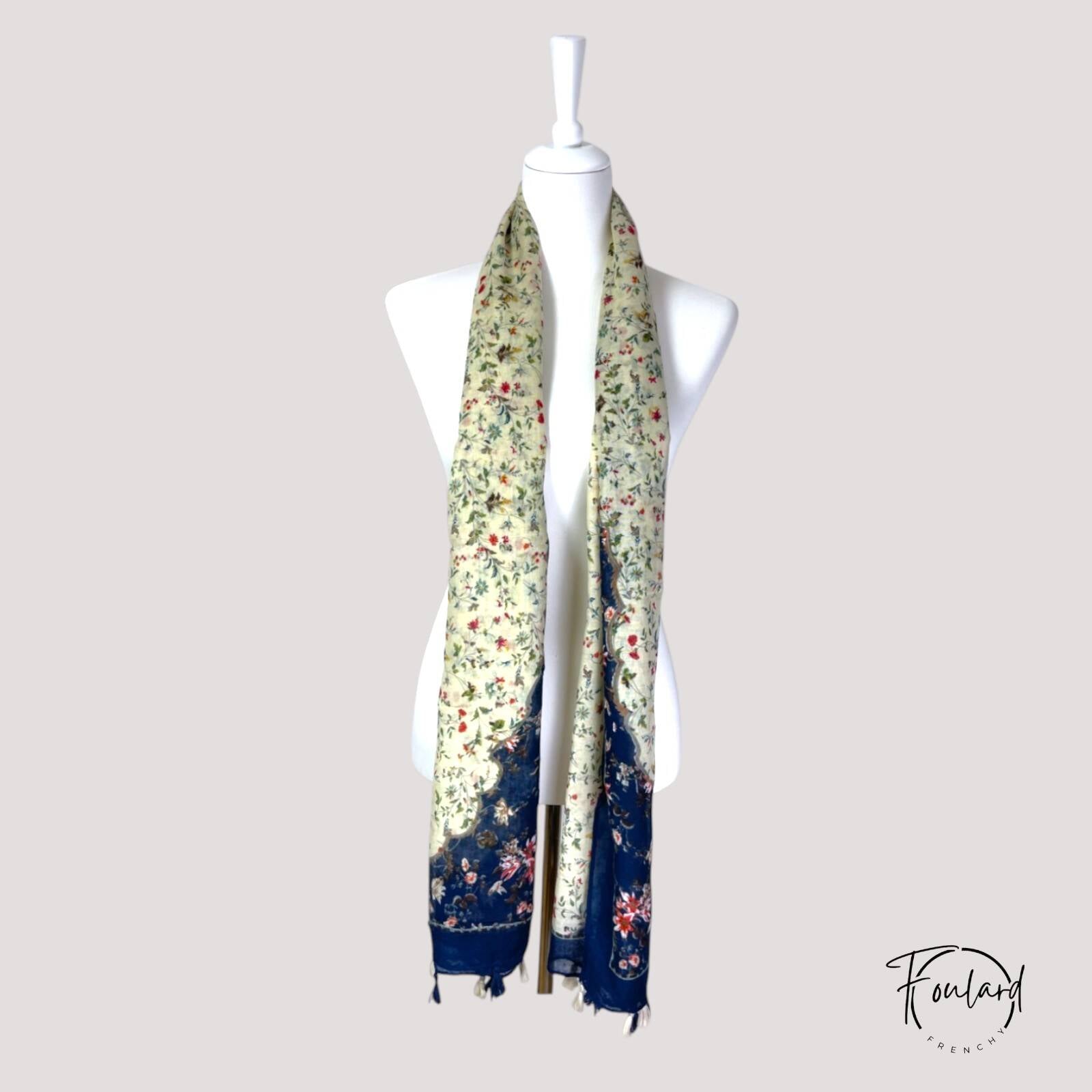 Détail du motif floral sur fond beige du foulard