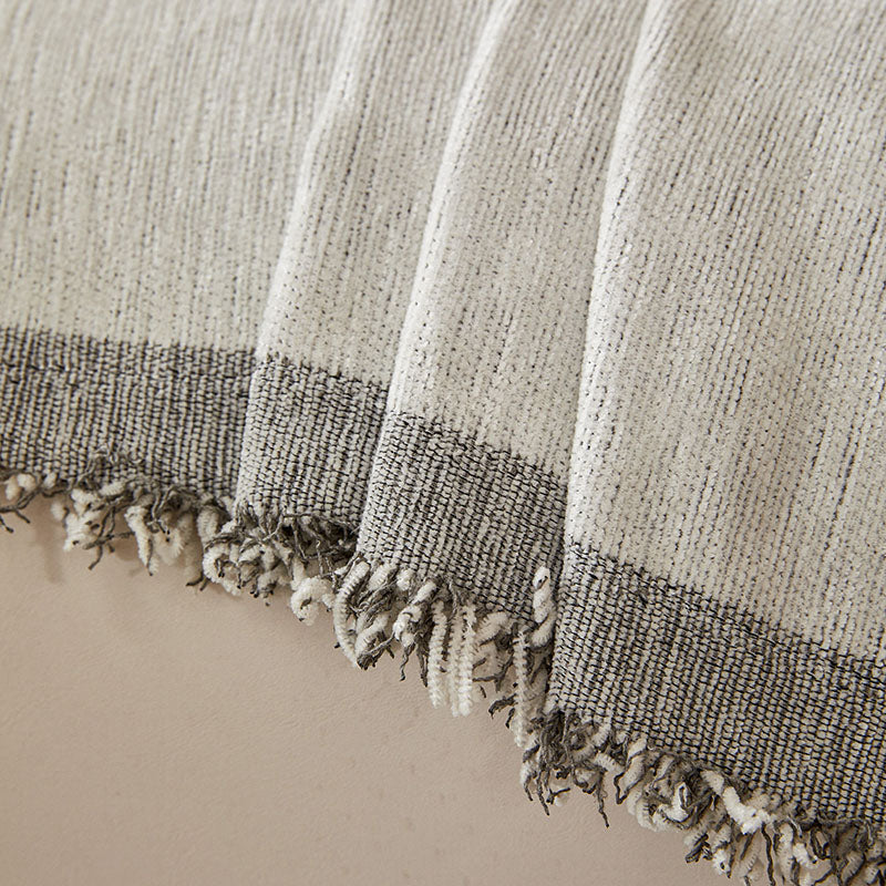 Jeté de canapé gris plié, montrant la texture du coton