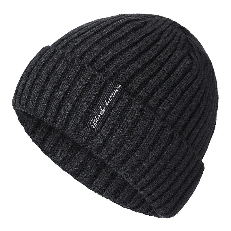 Bonnet noir posé sur une surface en bois clair