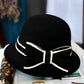 Gros plan sur un chapeau cloche en feutre, détail raffiné