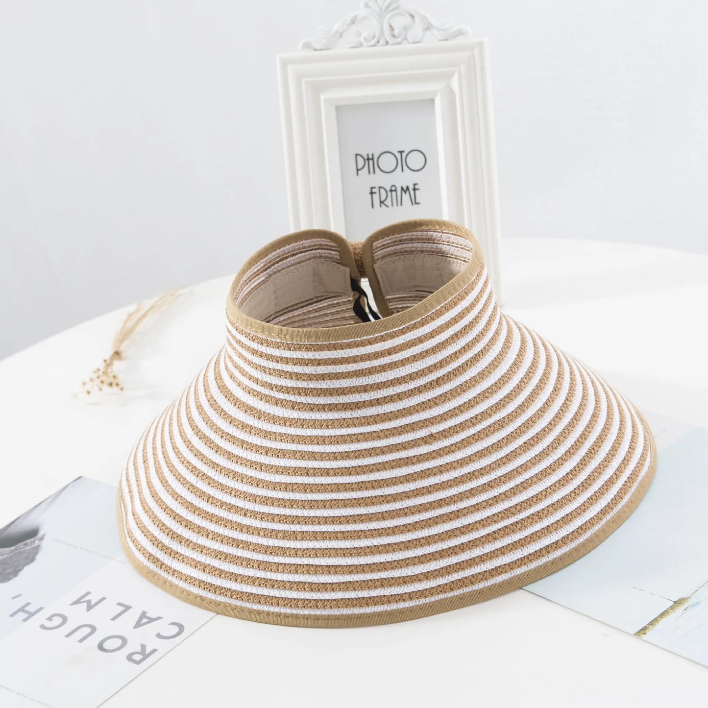 Chapeau de paille avec ruban noir, posé sur table