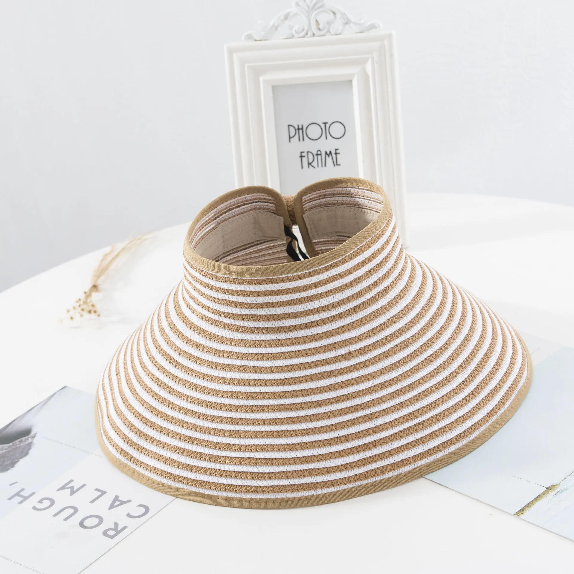 Chapeau de paille avec ruban noir, posé sur table