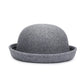 Chapeau melon avec une bordure fine, sur un fond de tissu beige