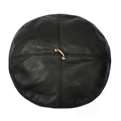 Femme élégante portant un béret en cuir, fond urbain