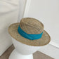 Chapeau de paille posé sur une chaise en osier