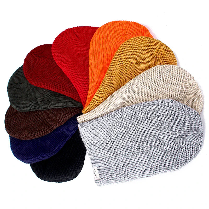 Bonnet rouge en tricot, posé sur une surface en bois