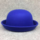 Chapeau melon avec un ruban noir, sur fond gris neutre