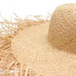 Gros plan sur la texture tressée d'un chapeau de paille