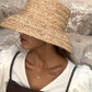 Gros plan sur la texture tressée du chapeau de paille