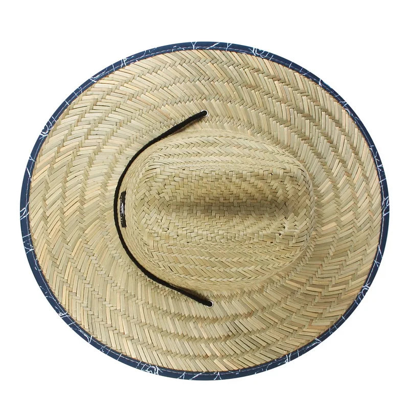 Chapeau de paille accroché à un mur ensoleillé