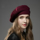 Femme souriante portant un béret, arrière-plan flou