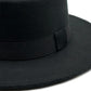 Chapeau Fedora bleu marine avec bande noire, posé sur une étagère