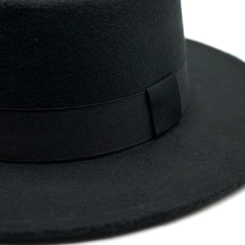 Chapeau Fedora bleu marine avec bande noire, posé sur une étagère