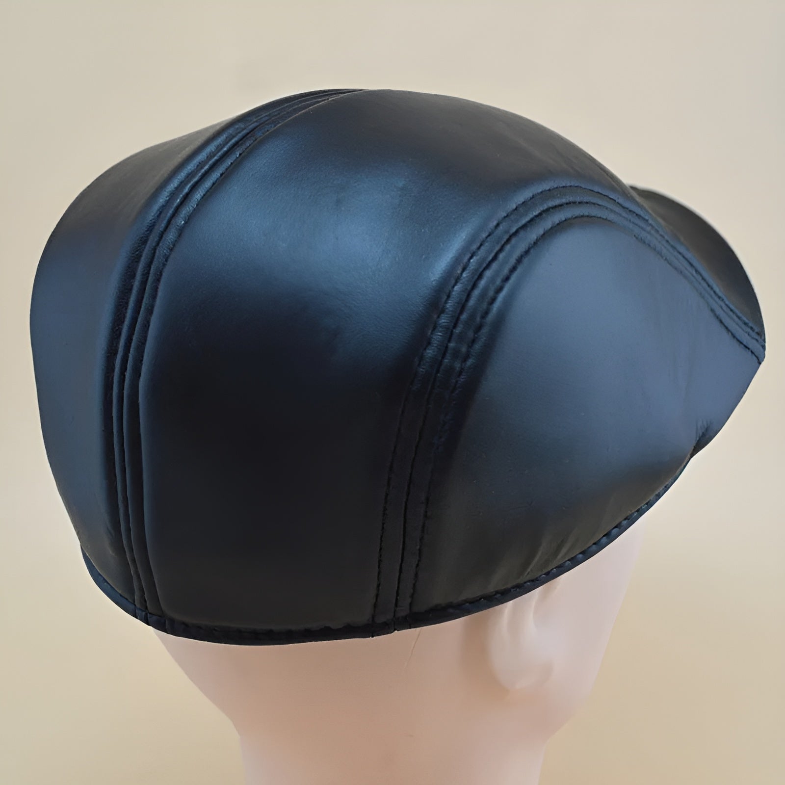 Homme portant un béret en similicuir, profil gauche